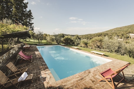 Una piscina al aire libre, sillones reclinables de piscina