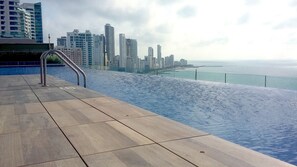 A poolside area with a view of a city skyline and the sea. - H2 LUXURY 3 Bedroom Apartment (Cartagena)