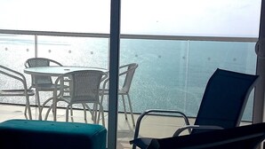 A balcony with a view of the sea, furnished with metal chairs and a table. - H2 LUXURY 3 Bedroom Apartment (Cartagena)