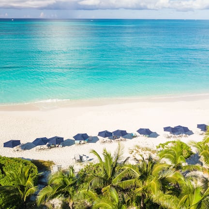 On the beach, white sand, sun loungers, beach umbrellas