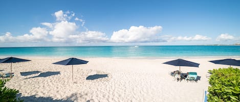 On the beach, white sand, sun-loungers, beach umbrellas