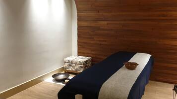 Cozy retreat with a single bed, wooden slat wall, and a small, patterned ottoman.