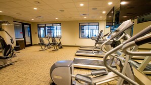 Un gimnasio con cintas de correr, elípticas y bicicletas estáticas.