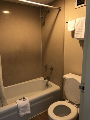 A bathroom with a bathtub, toilet, and shower.