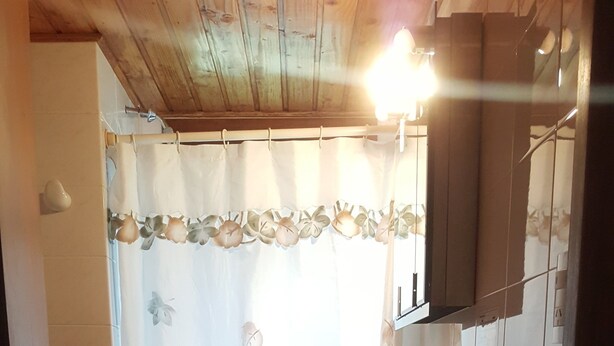 A small bathroom with a toilet, sink, and shower area. - Cabanas La Cautiva (Esquel)