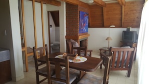 Un salon chaleureux avec une cheminée en briques, des meubles en bois et un téléviseur.