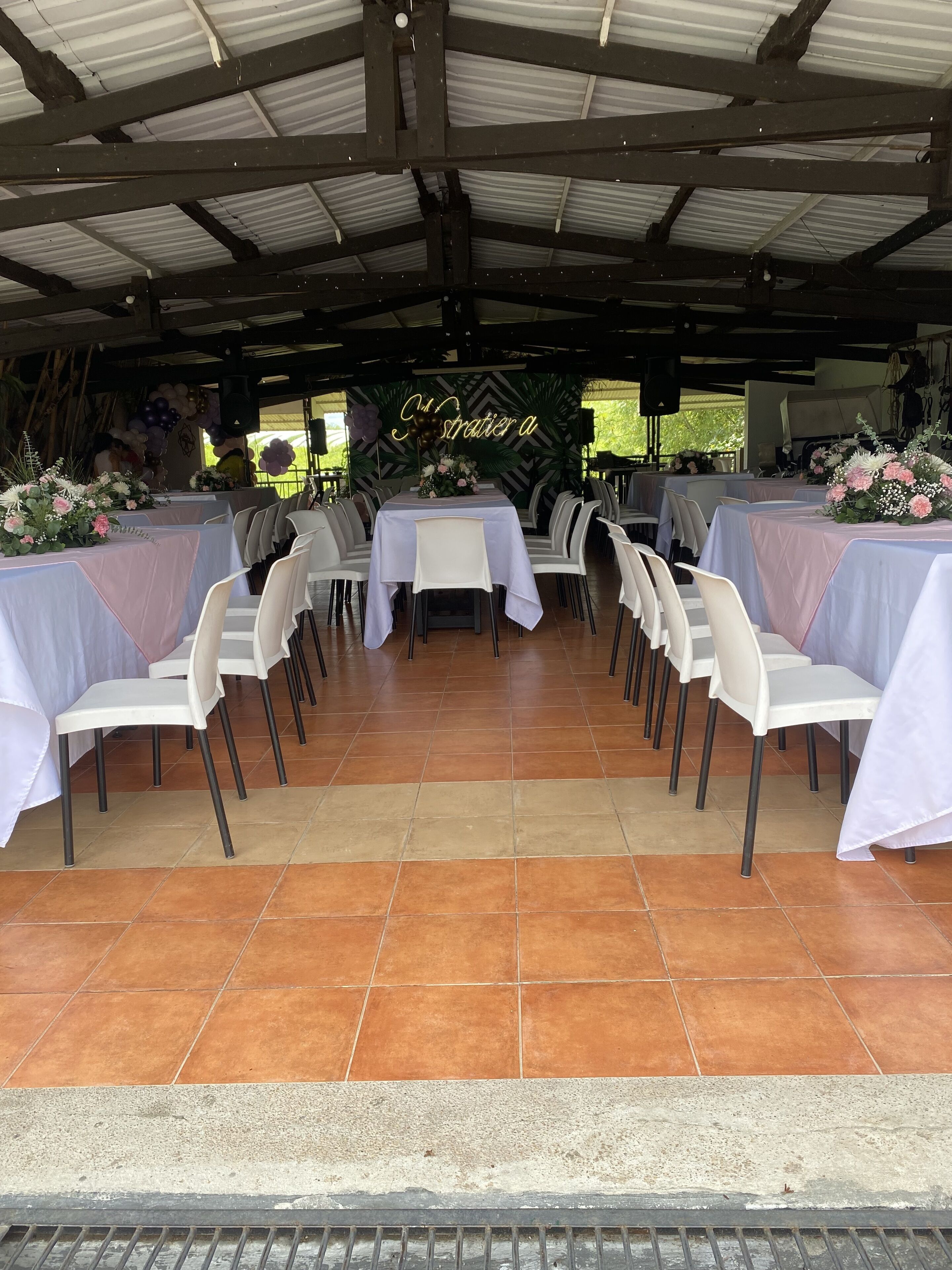 Un espace extérieur aménagé pour les événements, avec des tables et des chaises disposées pour accueillir les participants.