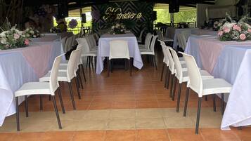 Un espace extérieur aménagé pour les événements, avec des tables et des chaises disposées pour accueillir les participants.