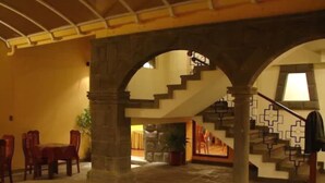 A lobby with stone arches, a staircase, and a seating area with chairs. - Imperial Cusco Hotel (Cusco)