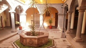A courtyard with a central planter, stone flooring, and columns. - Imperial Cusco Hotel (Cusco)