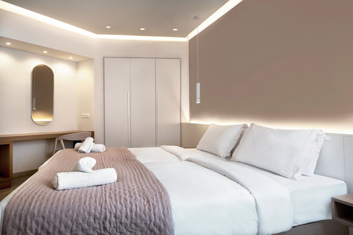 Una habitación de hotel moderna con una cama grande, un escritorio y un armario.