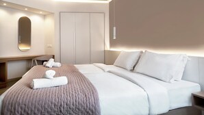 Ein modernes Hotelzimmer mit einem großen Bett, einem Schreibtisch und einem Kleiderschrank.