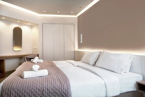 A modern hotel room with a large bed, a desk, and a wardrobe.