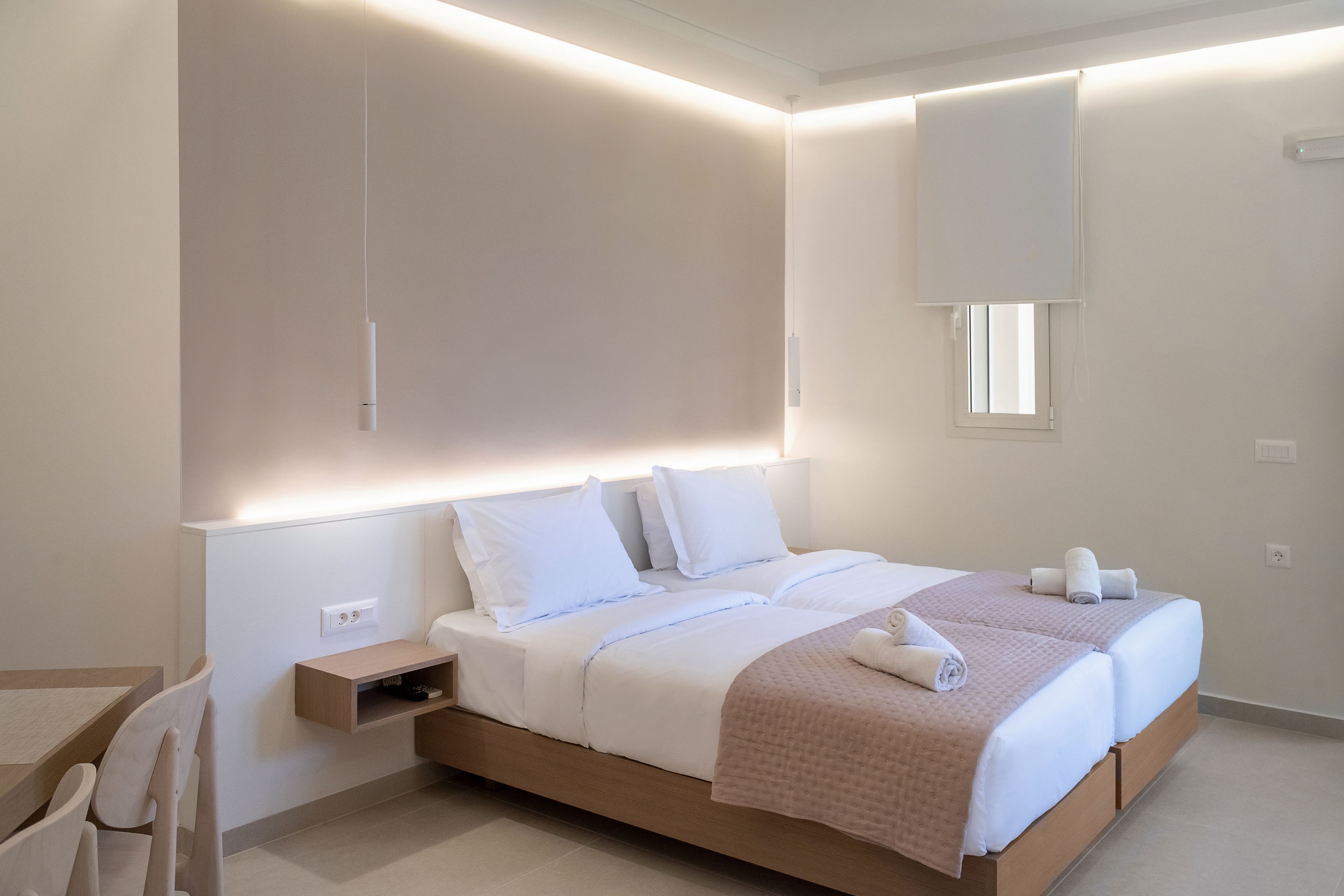 Quarto moderno com uma cama grande, mesas de cabeceira e uma estante embutida.