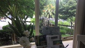 A wooden table with a vase of white flowers, a map stand with various maps, and a small sign asking for reviews. - Emerald Ridge (Emerald)