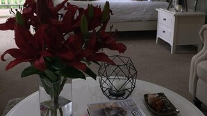 A bedroom with a bed, a nightstand, a bedside table, a lamp, and a window with curtains. - Emerald Ridge (Emerald)