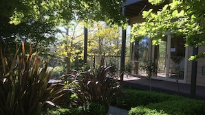 A garden area with various plants and a pathway leading to a building entrance. - Emerald Ridge (Emerald)