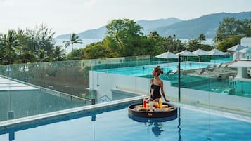 Una piscina al aire libre, sillones reclinables de piscina