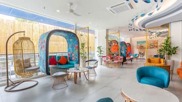 A modern interior with a seating area featuring a sofa, chairs, and a hanging chair.