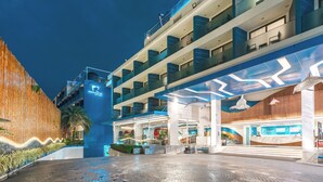 A modern hotel with multiple floors, a reception area, and a well-lit entrance. - Hotel Clover Patong Phuket (Patong)