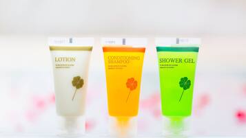 Three tubes of lotion, conditioner, and shower gel with clover designs.