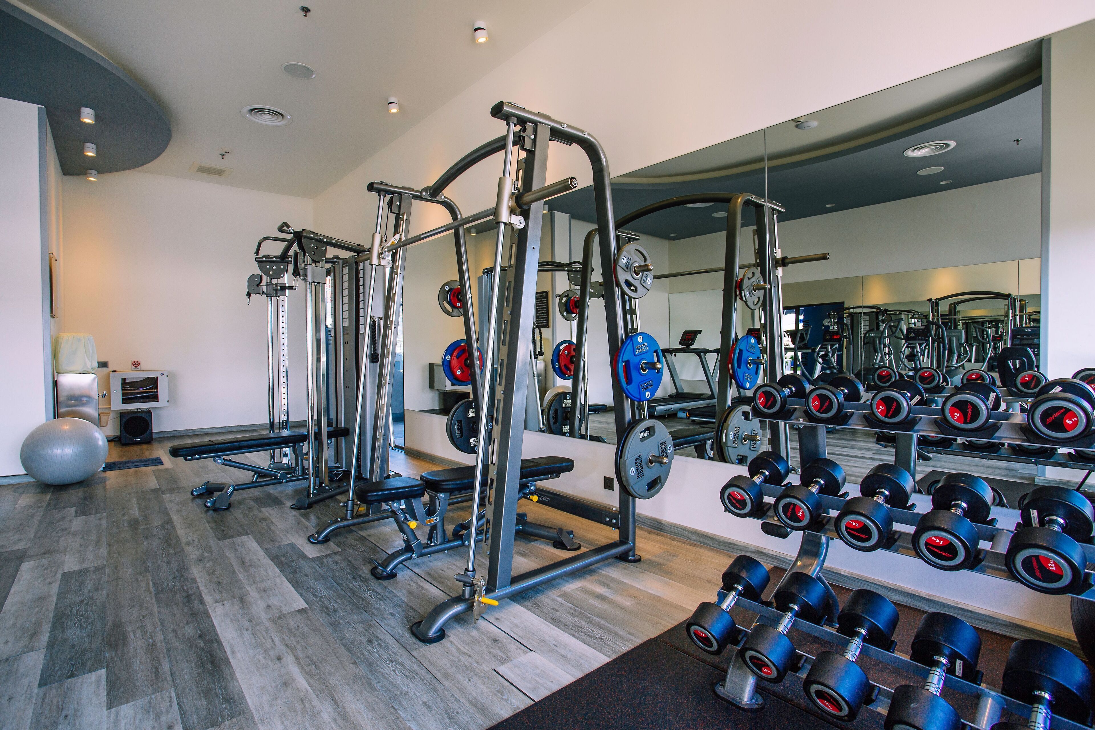 Een sportschool met gewichthefapparatuur, trainingsballen en dumbbells.