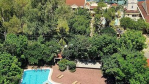 Un resort con una piscina grande, exuberante vegetación y vista al océano.