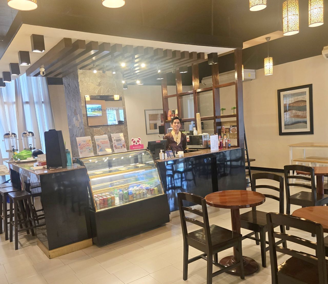 A restaurant interior with a counter, display case, and seating area.