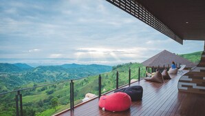 A wooden deck with a railing overlooking a lush valley. - Phu Sandao Resort (Khao Kho)