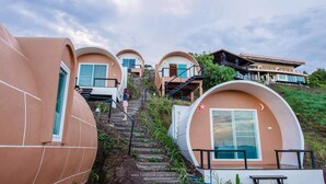 A series of dome-shaped buildings with external staircases leading to the entrance. - Phu Sandao Resort (Khao Kho)