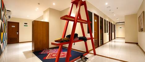A hallway with a red ladder, a patterned rug, and a door labeled 'M-301'.
