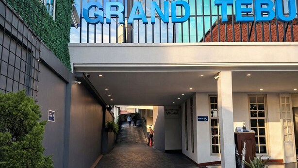 A hotel entrance with a sign reading 'GRAND TEBU,' a covered walkway, and a staircase leading to the entrance. - Subwow Hostel (Bandung)