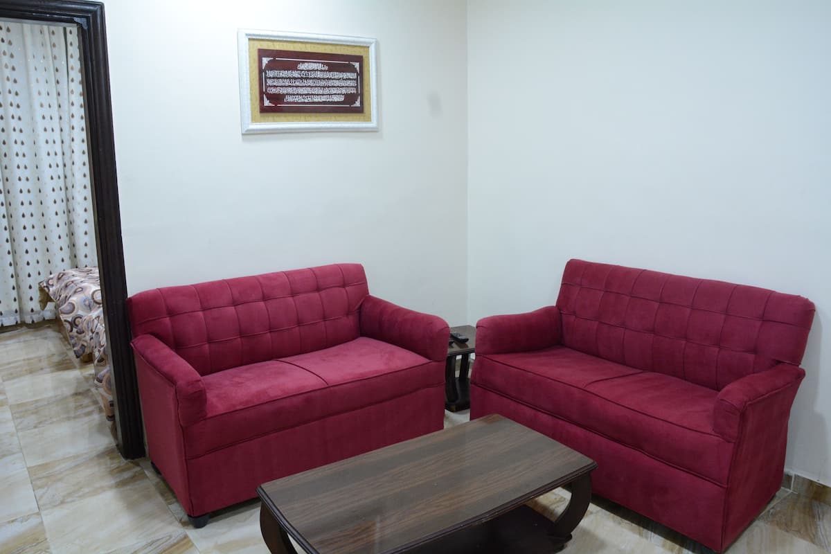 A room with two red sofas and a wooden coffee table.