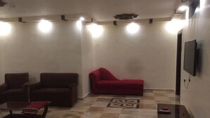 Un salon avec deux canapés, une table basse et un téléviseur fixé au mur.