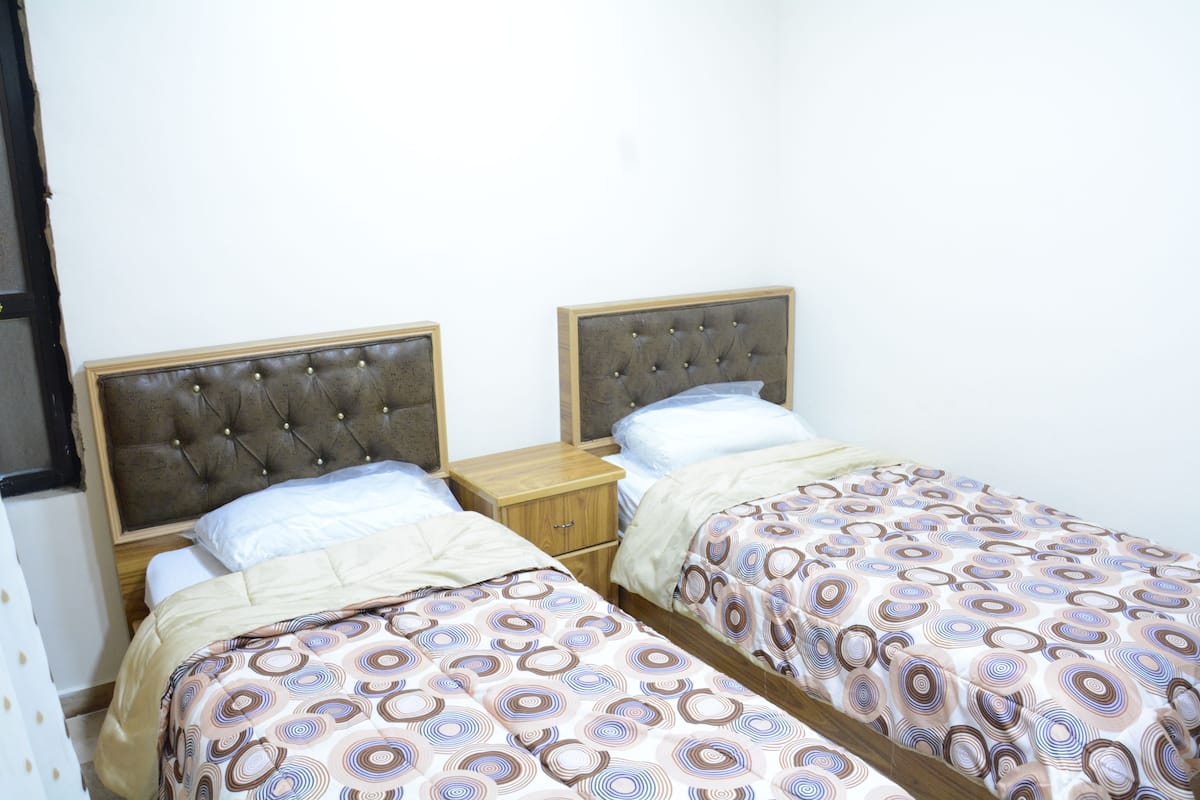 A twin room with two single beds, each with a wooden headboard and a matching nightstand.