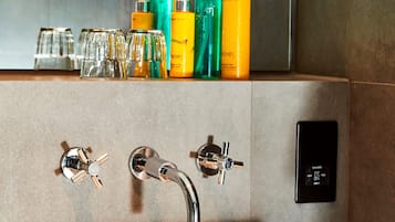 A bathroom with a beige sink, two chrome faucets, and a mirror above.