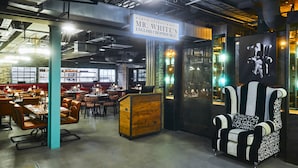 A restaurant interior with tables, chairs, and a distinctive black and white striped chair. - New Road Hotel (London)