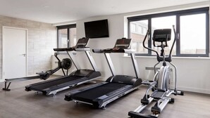 A gym with treadmills, elliptical machines, and a stationary bike.