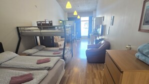 A dormitory room with bunk beds, a wooden desk, a chair, and a dresser. - Reykjanes Guesthouse (Grindavik)