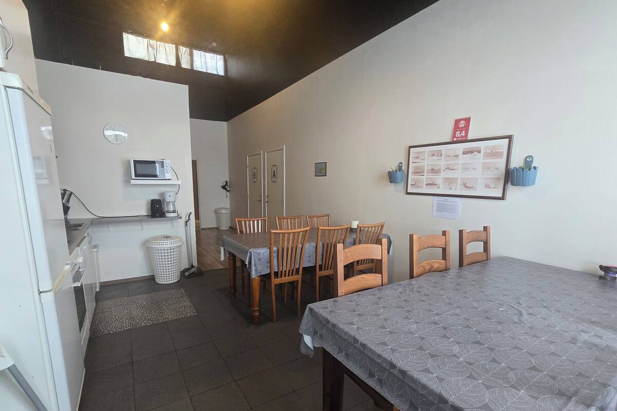 A compact kitchen with a dining area, including a table and chairs, a microwave, and a sink.
