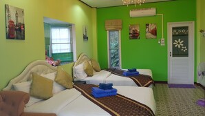 Ein Hotelzimmer mit zwei Betten, grünen Wänden und Kunstwerken, die Londoner Sehenswürdigkeiten zeigen.