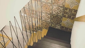 A staircase with a patterned tile wall and a metal railing. - Ad Hoc Rooms (Palermo)