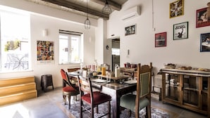 A dining area with a wooden table, chairs, and a patterned rug. - Ad Hoc Rooms (Palermo)