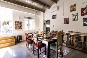 Un coin repas avec une table en bois, des chaises et un tapis à motifs.