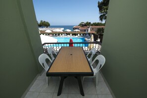 A balcony with a view of a swimming pool and the sea. - Otel Diyojen (Sinop)