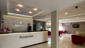 A hotel reception area with a modern design, featuring a reception desk labeled "Resepsiyon" and a visible "Otel Diyojen" sign. - Otel Diyojen (Sinop)
