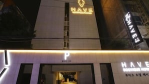 A hotel entrance with a prominent 'HAVE' sign, a parking sign, and a visible entrance door. - Boutique Hotel HAVE (Busan)