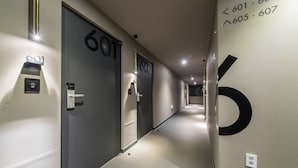 A modern hotel corridor with doors numbered 601 and 602, and a large number 6 on the wall. - Boutique Hotel HAVE (Busan)