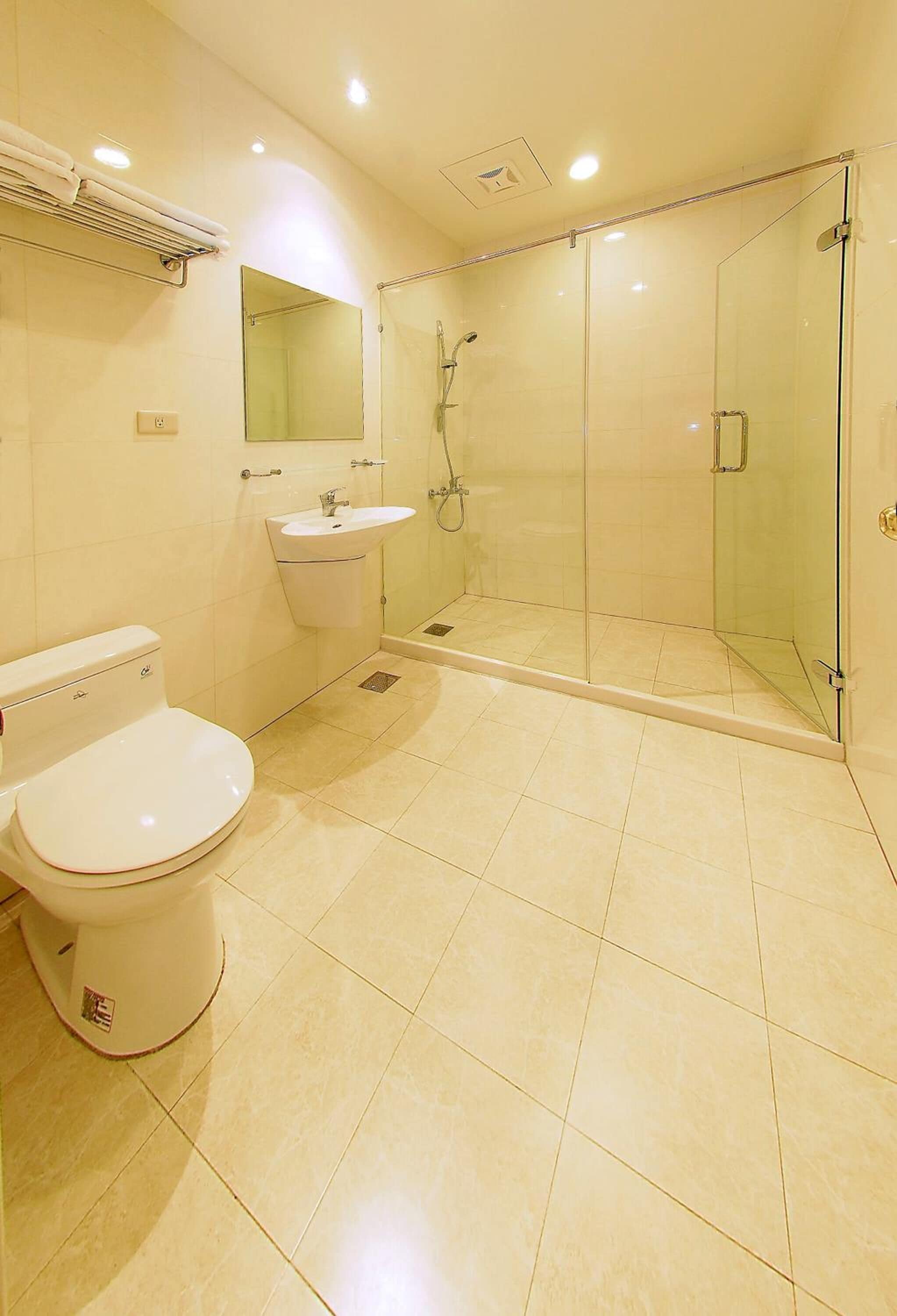A modern bathroom with a toilet, sink, and glass-enclosed shower.