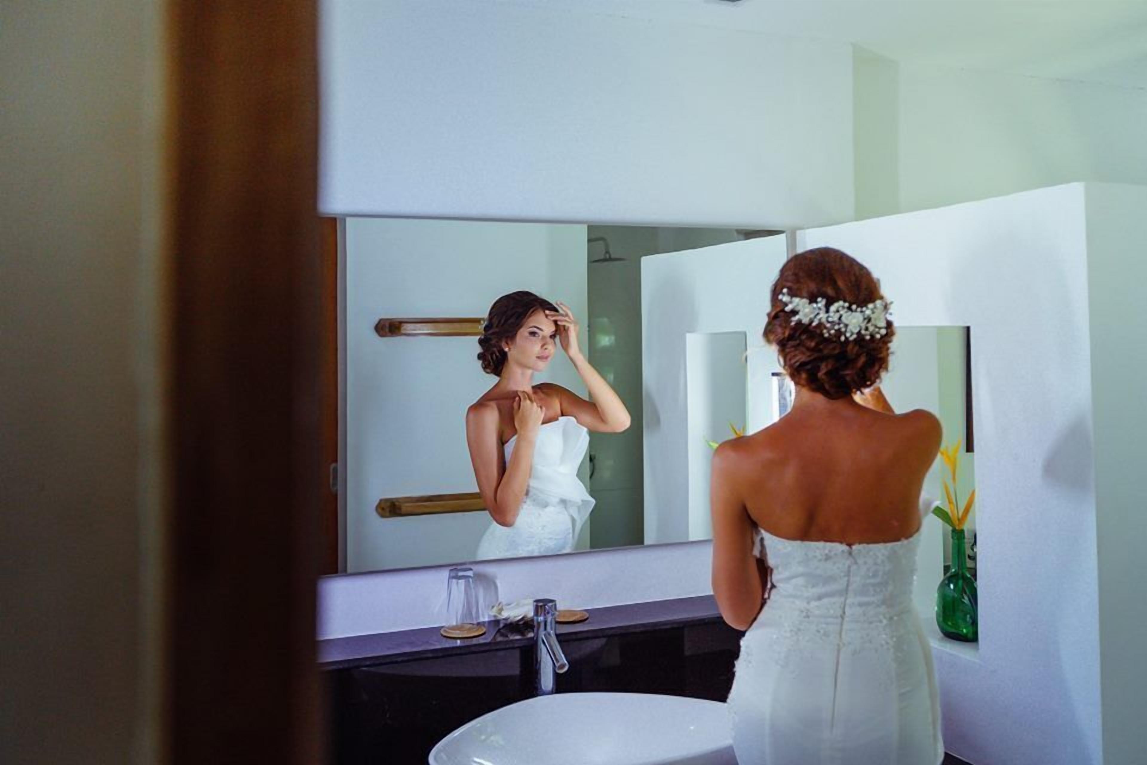 A bathroom with a large mirror, a sink, and a towel rack.
